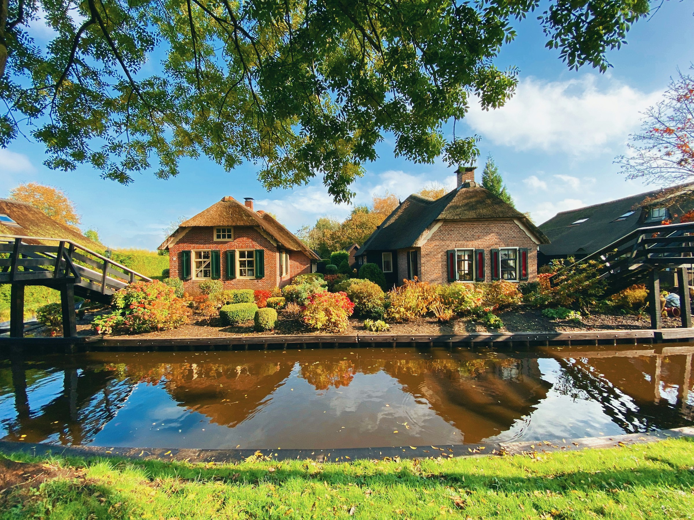 Giethoorn canals, wooden footbridges, and charming thatched-roof cottages in Giethoorn