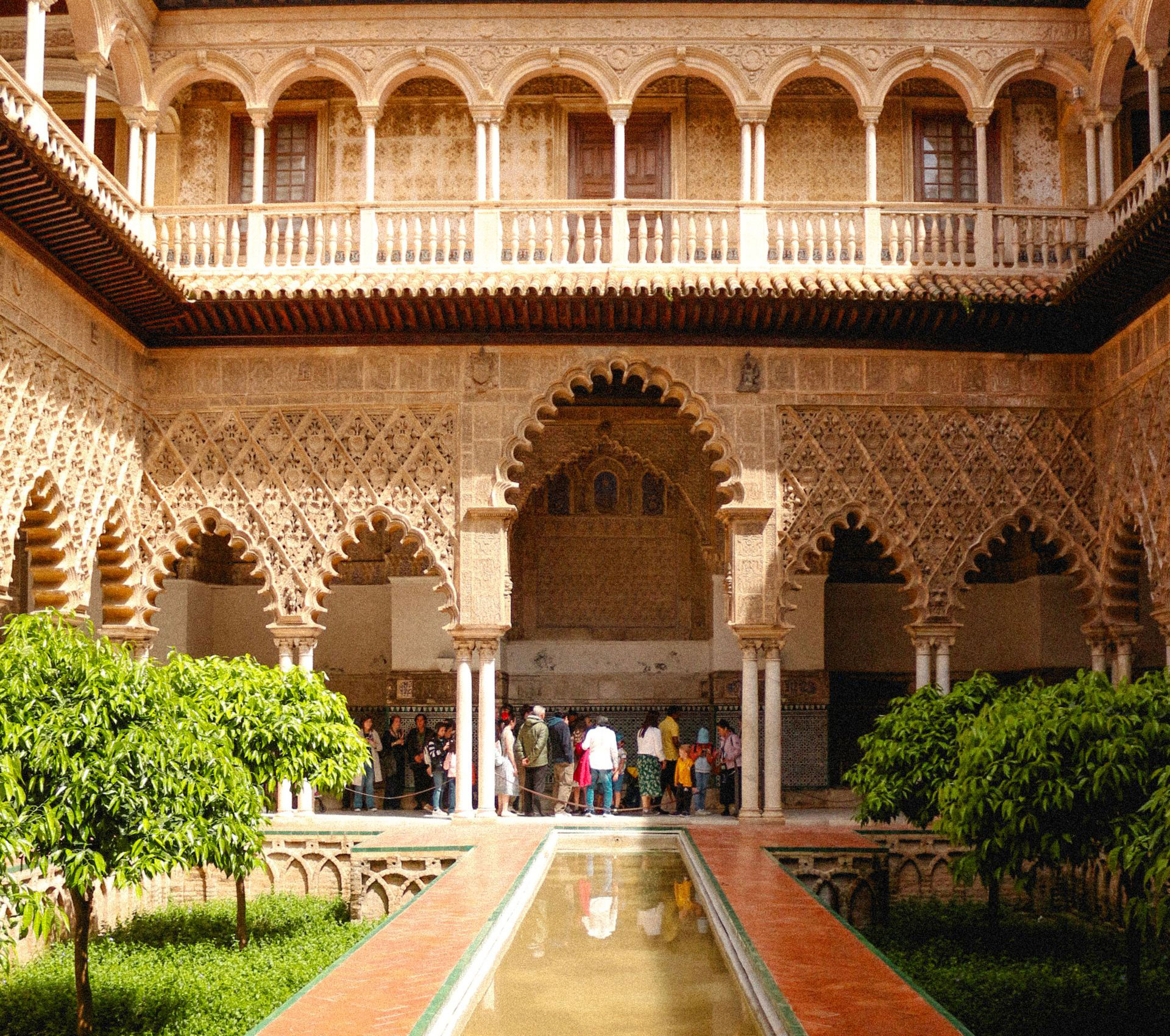 Seville Real Alcázar courtyard, arches and greenery in Seville