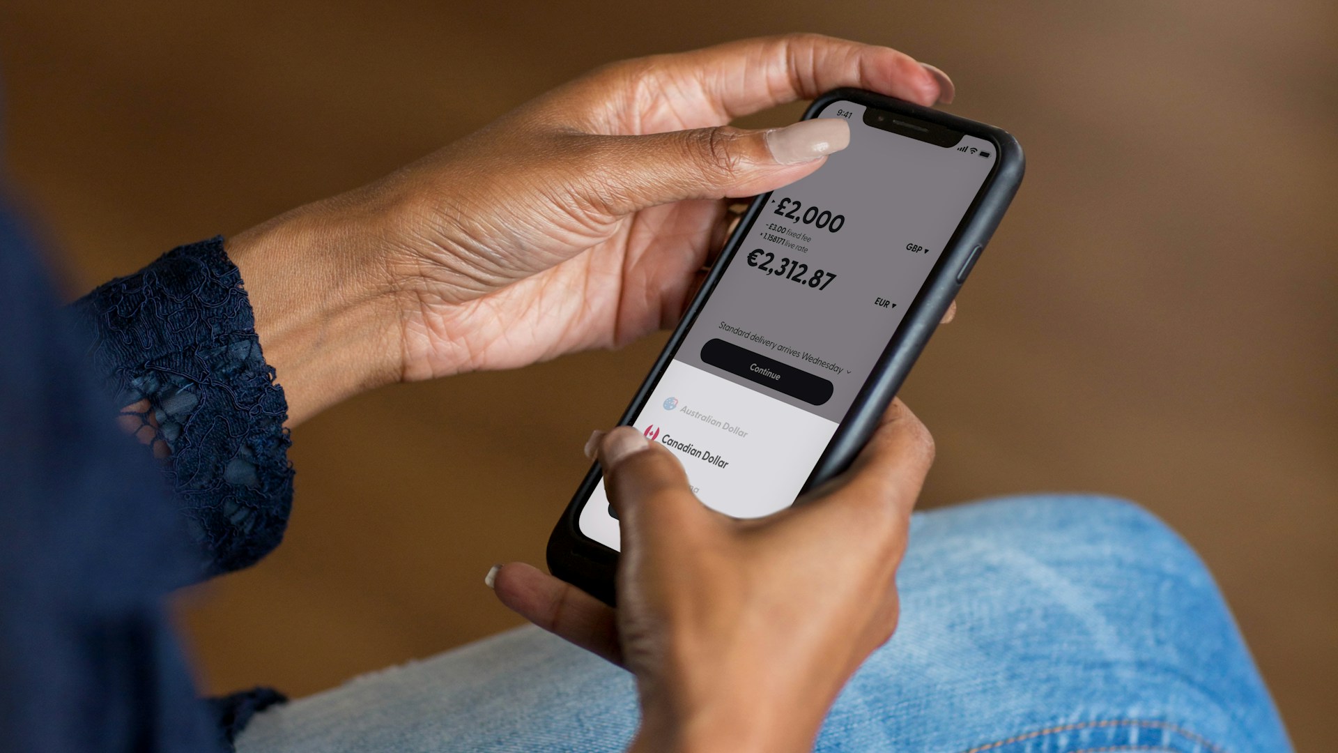 a phone showing a multi-currency banking app with several currency balances a phone showing a multi-currency banking app with several currency balances