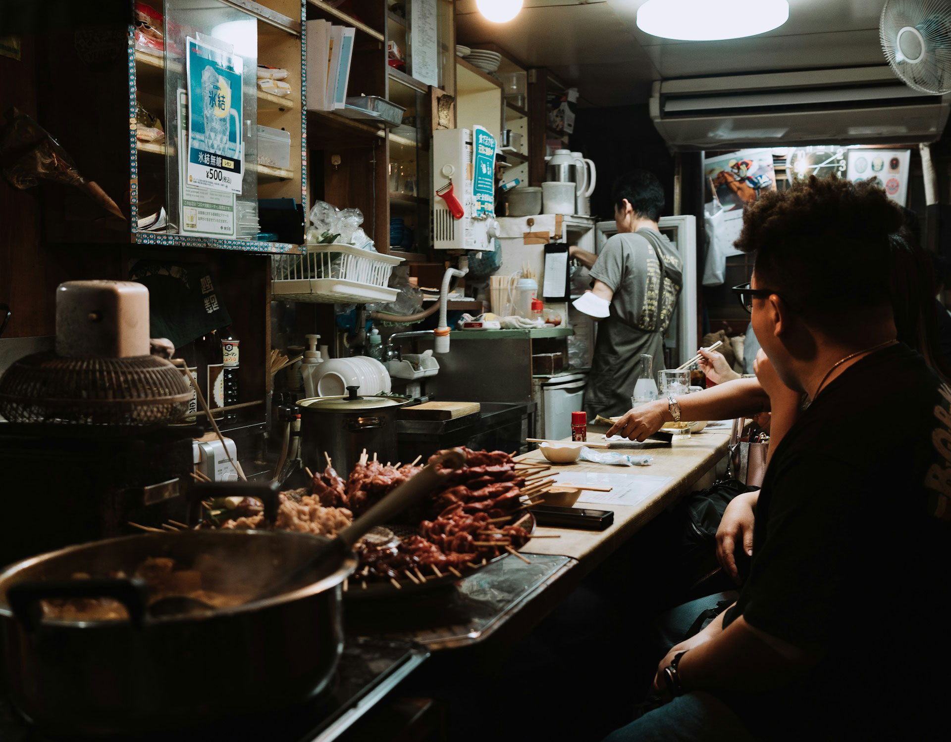 Japan a solo traveller eating at a small counter restaurant in Japan