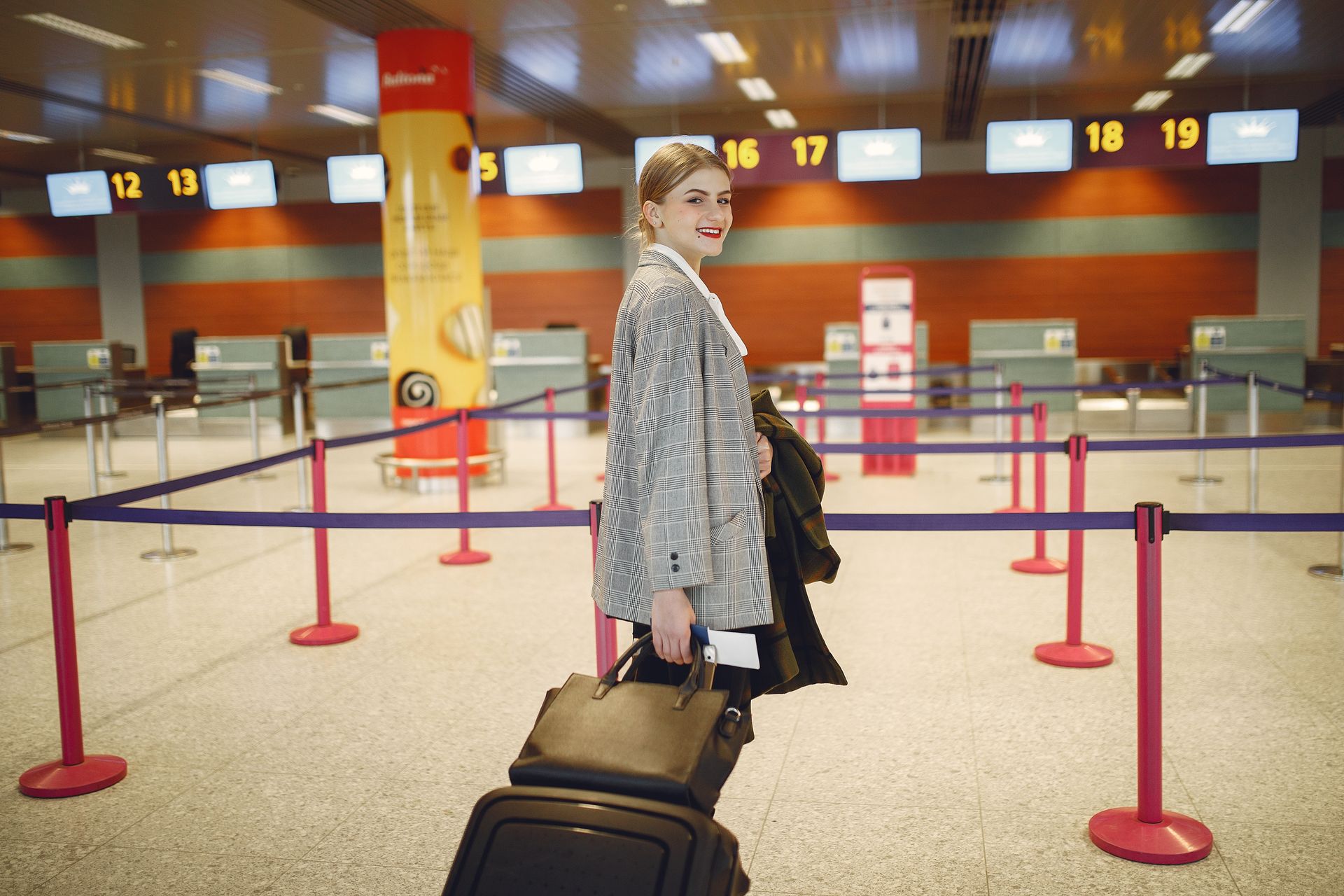 a traveller checking in at an airport counter, smart casual dress a traveller checking in at an airport counter, smart casual dress
